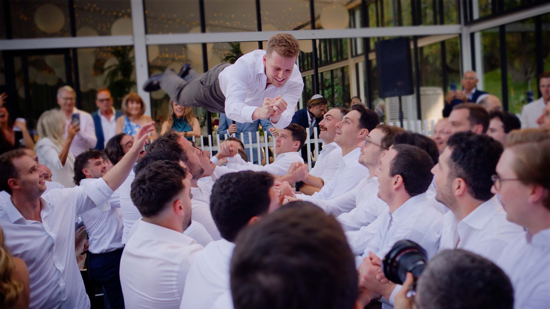 Horas on the front lawn at Alto in the Royal Botanic Gardens, with guests lifting Chelsey and Jesse on chairs