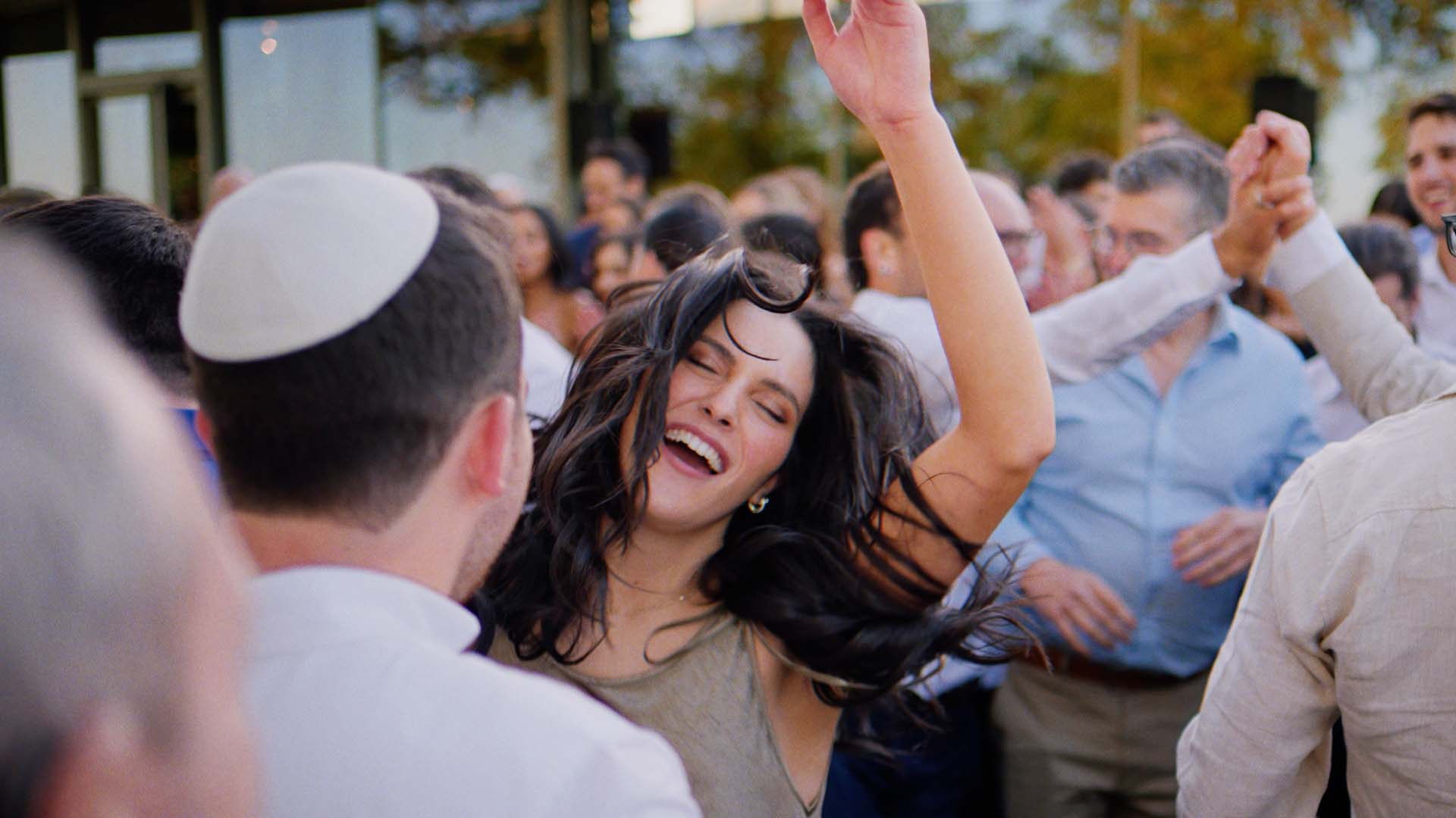 High-energy reception entrance with guests waving towels at Taylor and Kelsey's Pt. Leo Estate wedding