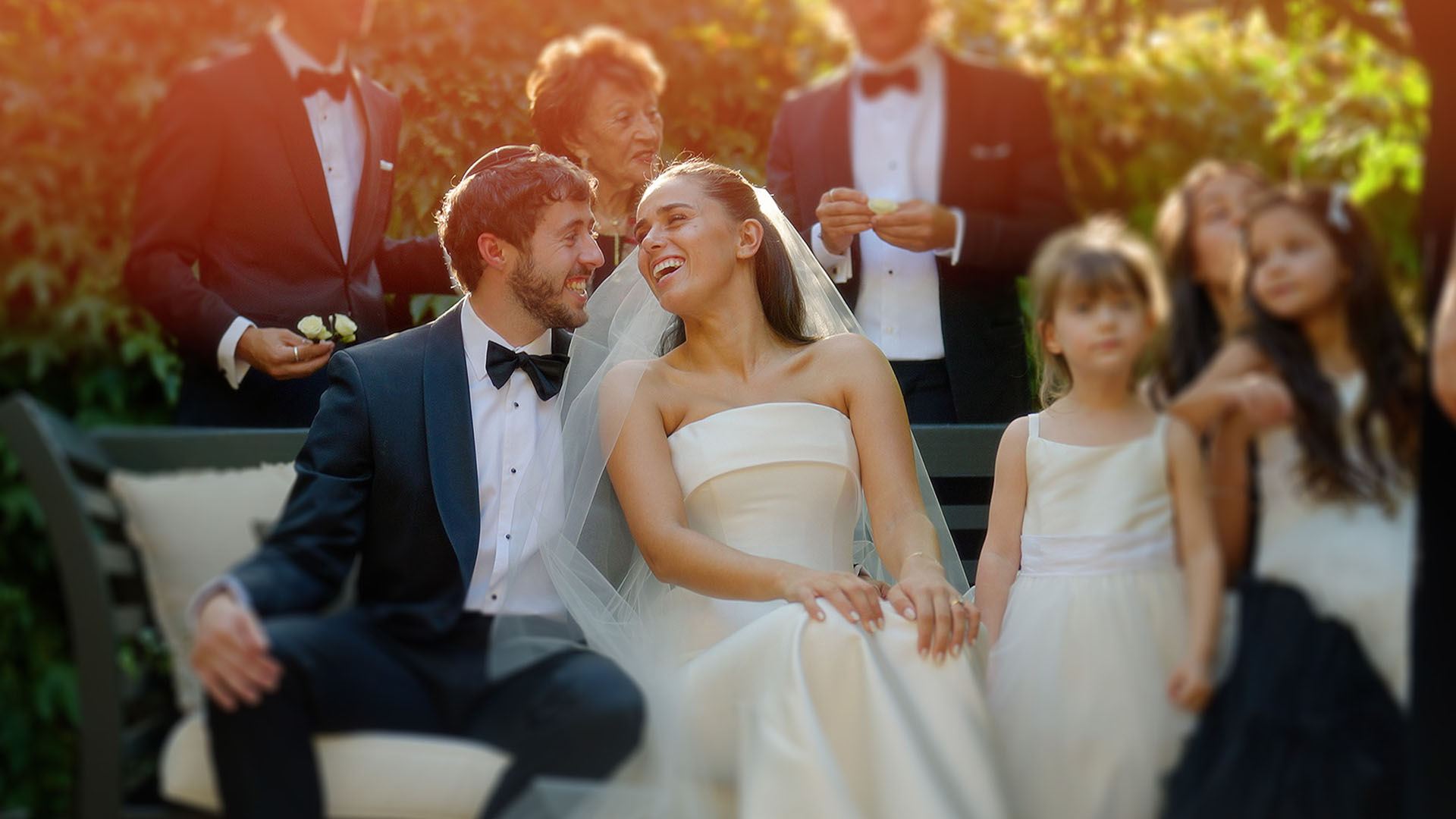 Khya and Sam laughing together surrounded by family at Stones of the Yarra Valley, a still from their Sea of Love wedding film